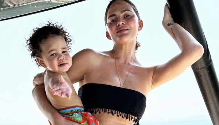 Chrissy Teigen poses with her son Wren on a yacht